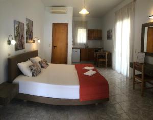 a bedroom with a large bed and a kitchen at Chrisanthi Studios & Apartments in Plakias