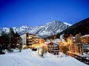 a hotel in the snow with a mountain in the background at Hotel Bristol in Saas-Fee