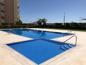 a large blue swimming pool in front of a building at Apartamento Terraza Mar El Azul in Santa Susanna
