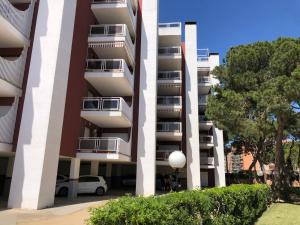 a tall apartment building with cars parked in front of it at Apartamento Terraza Mar El Azul in Santa Susanna