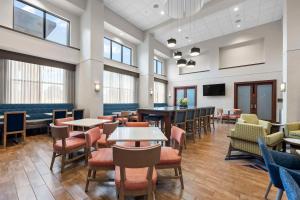 開普吉拉多的住宿－拉杜角I-55東，MO漢普頓酒店，用餐室设有桌椅和窗户。