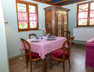 uma sala de jantar com uma mesa com uma toalha de mesa rosa em Origin'alsace em Kaysersberg