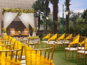 a row of chairs and tables with yellow bows at Novotel Lucknow Gomti Nagar in Lucknow