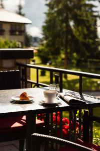 a table with a cup of coffee and a pastry on it at Cresta Palace Celerina in Celerina