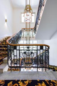 a staircase with a chandelier in a house at Cresta Palace Celerina in Celerina