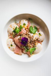 a bowl of food with meat and a purple flower at Cresta Palace Celerina in Celerina