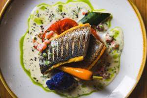 a plate of food with vegetables and sauce at Cresta Palace Celerina in Celerina