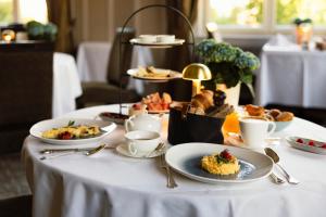 a table with plates of food and cups of coffee at Cresta Palace Celerina in Celerina