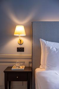 a lamp on a table next to a bed at Cresta Palace Celerina in Celerina