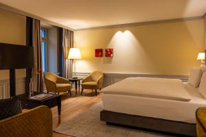 a hotel room with a bed and a table and chairs at Cresta Palace Celerina in Celerina