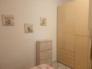 ein Schlafzimmer mit einem Bett und einer Kommode mit zwei Bildern an der Wand in der Unterkunft Casa Vacanze Keti in Viareggio