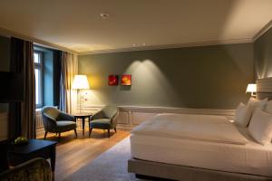 a hotel room with a bed and a table and chairs at Cresta Palace Celerina in Celerina