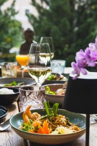 a table with a plate of food and a glass of wine at Cresta Palace Celerina in Celerina