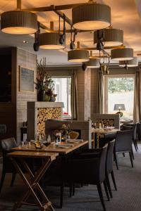 a restaurant with wooden tables and chairs and lights at Cresta Palace Celerina in Celerina