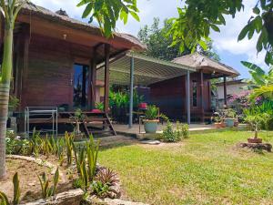 a wooden house with a bench in a yard at Yellow Coco Gili Gede in Gili Gede