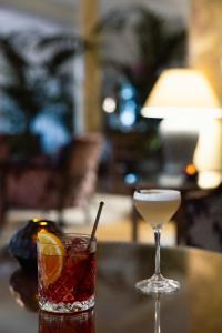 a drink and a martini sitting on a table at Cresta Palace Celerina in Celerina