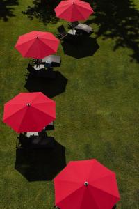 a group of red umbrellas sitting on the grass at Cresta Palace Celerina in Celerina