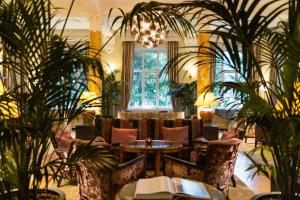 a lobby with chairs and tables and plants at Cresta Palace Celerina in Celerina