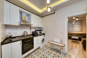 uma cozinha com armários brancos e uma máquina de lavar e secar roupa em HAGİA Detached House em Istambul