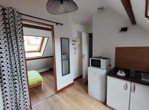een keuken met een deur naar een keuken met een magnetron bij Studio éco près du port in Boulogne-sur-Mer