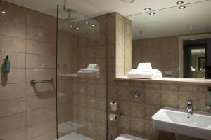 a bathroom with a glass shower and a sink at Sandford House Hotel Wetherspoon in Huntingdon