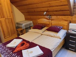 a bedroom with two beds in a log cabin at Willa Rycerz in Niedzica Zamek