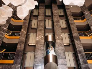 a bride and groom standing in the elevator of a building at Rixos Krasnaya Polyana Sochi in Estosadok