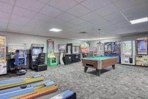 Quality Inn & Suites Downtown في غرين باي: غرفة ألعاب مع طاولة بلياردو وألات ألعاب