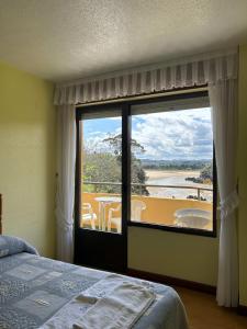 イスラにあるApartamentos de la Hozのベッドルーム1室(景色を望む大きな窓付)