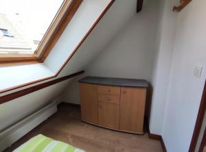 een kleine kast in de hoek van een kamer met een raam bij Studio éco près du port in Boulogne-sur-Mer