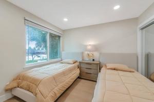 1 Schlafzimmer mit 2 Betten und einem Fenster in der Unterkunft Luxe Home Steps from Mall and Downtown Escape in San Jose