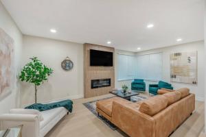 ein Wohnzimmer mit einem Sofa und einem TV in der Unterkunft Luxe Home Steps from Mall and Downtown Escape in San Jose