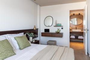 een slaapkamer met een bed met een wastafel en een spiegel bij Albatros Spa & Resort Hotel in Chersonissos