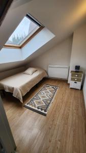een slaapkamer op zolder met een bed en een raam bij Maison L'Atelier des Salines in Lons-le-Saunier