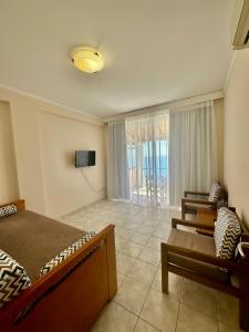 a bedroom with a bed and a couch and a tv at Lido Sofia Apartments in Agios Gordios