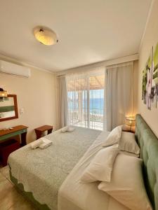 a bedroom with a large bed and a window at Lido Sofia Apartments in Agios Gordios