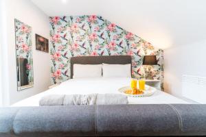 een slaapkamer met een groot bed met bloemen aan de muur bij Moseley Haven 2 - Bed Luxury in Birmingham