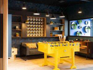 a yellow game table in a room with a couch at ibis Styles Dreux Centre Gare in Dreux