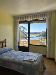 a bedroom with a bed and a large window at Apartamentos de la Hoz in Isla