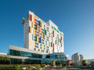 马尼拉ibis Styles Manila Araneta City的一座大型建筑,上面有五颜六色的窗户