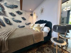 um quarto com uma cama e uma parede com sapatos em MAISON La BOHEME Spa & Jacuzzi em Vias