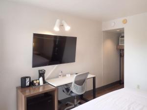 a bedroom with a desk and a tv on the wall at La Luna Inn, Ascend Hotel Collection in San Francisco