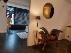 a living room with a chair and a mirror at rembrandtsbeachsuite in Zandvoort