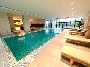 a large swimming pool in a building with benches at BW TERRACE top floor apartments with river view & self check-in in Belgrade