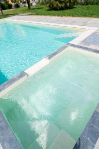 a swimming pool with blue water in a yard at Il Gattino di Porto - apt 6 - Monolocale terrazzo piscina in Imperia