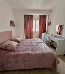 een slaapkamer met een bed en een bureau bij Escondite central con terraza compartida en la azotea y cocina compartida in Roses