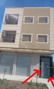 a building with a red arrow next to a door at Appart Hicham in Tangier
