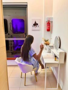 a girl sitting in a chair at a desk at Berloga Capsule JBR in Dubai