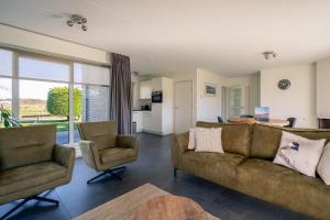 sala de estar con sofá y 2 sillas en Hoogelandt 90A, en De Koog