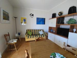 ein Wohnzimmer mit einem Sofa und einem TV in der Unterkunft Bilocale Jonio in Mascali